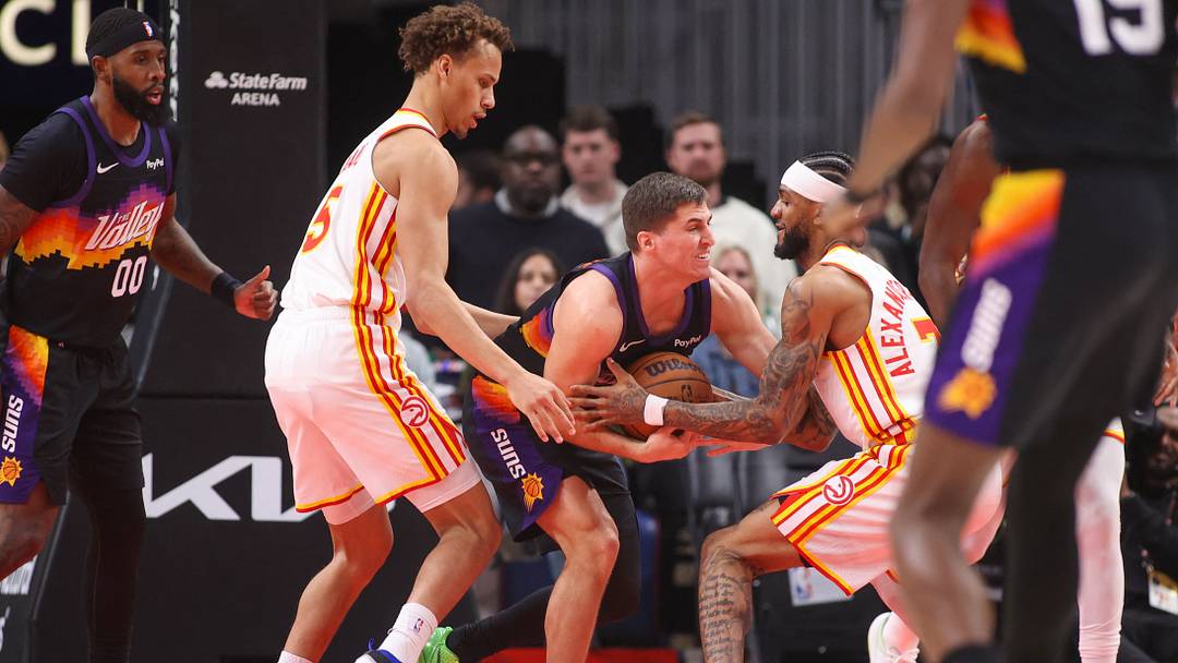 Jan 23, 2026; Atlanta, Georgia, USA; Phoenix Suns guard Collin Gillespie (12) grabs a loose ball past Atlanta Hawks guard Dyson Daniels (5) and guard Nickeil Alexander-Walker (7) in the first quarter at State Farm Arena. Mandatory Credit: Brett Davis-Imagn Images
