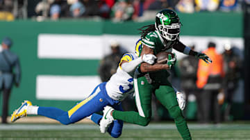 Dec 22, 2024; East Rutherford, New Jersey, USA; New York Jets wide receiver Davante Adams (17) fights for yards  as Los Angeles Rams safety Quentin Lake (37) tackles during the first half at MetLife Stadium. Mandatory Credit: Vincent Carchietta-Imagn Images