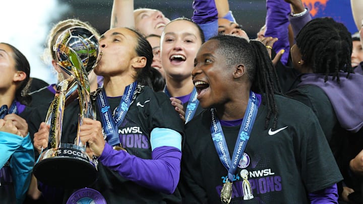 Orlando Pride forwards Marta (left) and Barbra Banda (right) celebrate with the NWSL championship trophy.