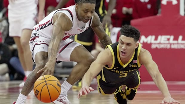 Wisconsin guard Kamari McGee (4) and Oregon guard Jackson Shelstad (3) vie for the ball during the first half