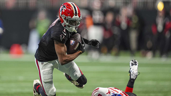 Dec 22, 2024; Atlanta, Georgia, USA; Atlanta Falcons wide receiver Darnell Mooney (1) flies over a tackle by New York Giants safety Jason Pinnock (27) at Mercedes-Benz Stadium. Mandatory Credit: Dale Zanine-Imagn Images