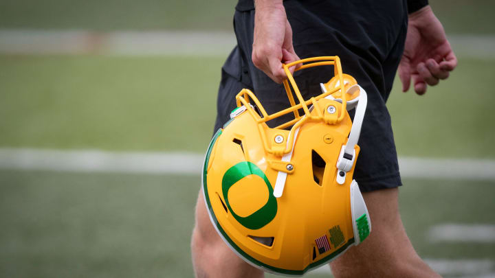 An Oregon football helmet is carried during practice with the Oregon Ducks Tuesday, Aug. 27, 2024 at the Hatfield-Dowlin Complex in Eugene, Ore.