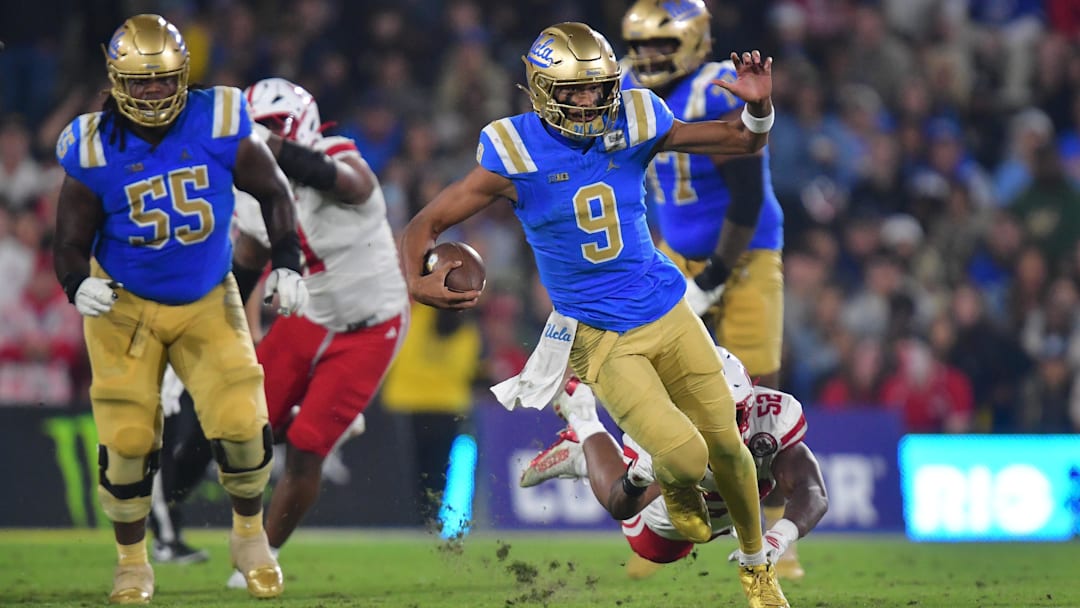 Nov 8, 2025; Pasadena, California, USA; UCLA Bruins quarterback Nico Iamaleava (9) runs the ball ahead of Nebraska Cornhuskers linebacker Dylan Rogers (52) during the first half at the Rose Bowl. Mandatory Credit: Gary A. Vasquez-Imagn Images