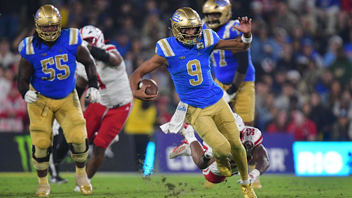 Nov 8, 2025; Pasadena, California, USA; UCLA Bruins quarterback Nico Iamaleava (9) runs the ball ahead of Nebraska Cornhuskers linebacker Dylan Rogers (52) during the first half at the Rose Bowl. Mandatory Credit: Gary A. Vasquez-Imagn Images