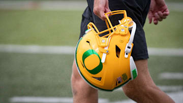 An Oregon football helmet is carried during practice with the Oregon Ducks Tuesday, Aug. 27, 2024 at the Hatfield-Dowlin Complex in Eugene, Ore.