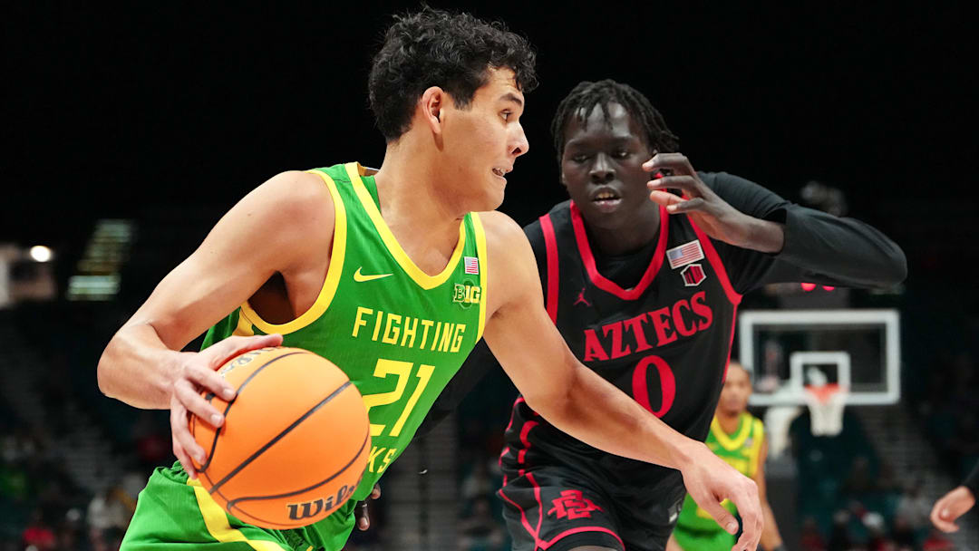 Nov 27, 2024; Las Vegas, Nevada, USA; Oregon Ducks forward Brandon Angel (21) dribbles against San Diego State Aztecs forward Magoon Gwath (0) during the first half at MGM Grand Garden Arena. Mandatory Credit: Stephen R. Sylvanie-Imagn Images