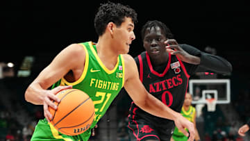 Nov 27, 2024; Las Vegas, Nevada, USA; Oregon Ducks forward Brandon Angel (21) dribbles against San Diego State Aztecs forward Magoon Gwath (0) during the first half at MGM Grand Garden Arena. Mandatory Credit: Stephen R. Sylvanie-Imagn Images