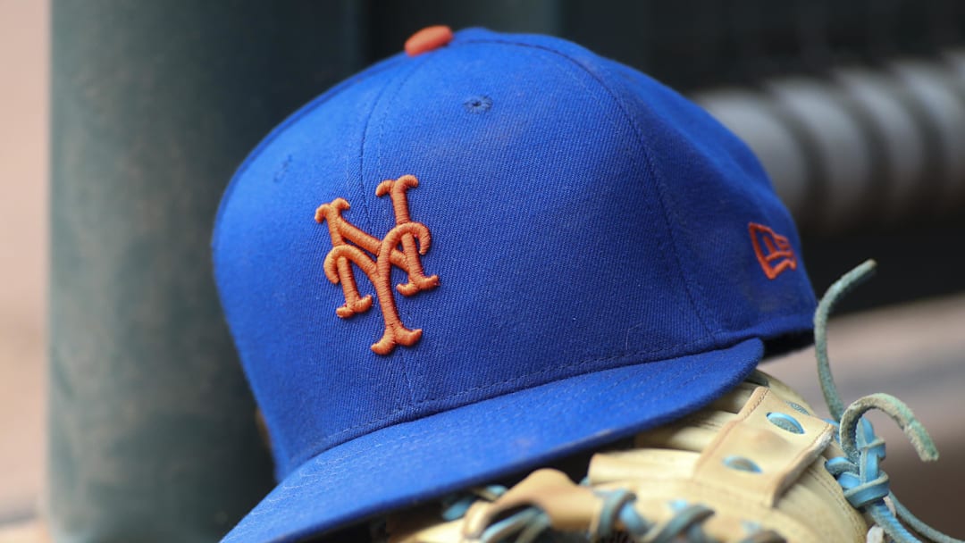 Jul 13, 2022; Atlanta, Georgia, USA; A detailed view of a New York Mets hat and glove in the dugout against the Atlanta Braves in the eighth inning at Truist Park. 