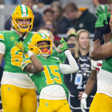 Jan 1, 2024; Glendale, AZ, USA; Oregon Ducks wide receiver Tez Johnson (15) celebrates with offensive lineman Steven Jones (74) and tight end Patrick Herbert (88) after scoring a touchdown against the Liberty Flames during the second half in the 2024 Fiesta Bowl at State Farm Stadium. Mandatory Credit: Mark J. Rebilas-USA TODAY Sports