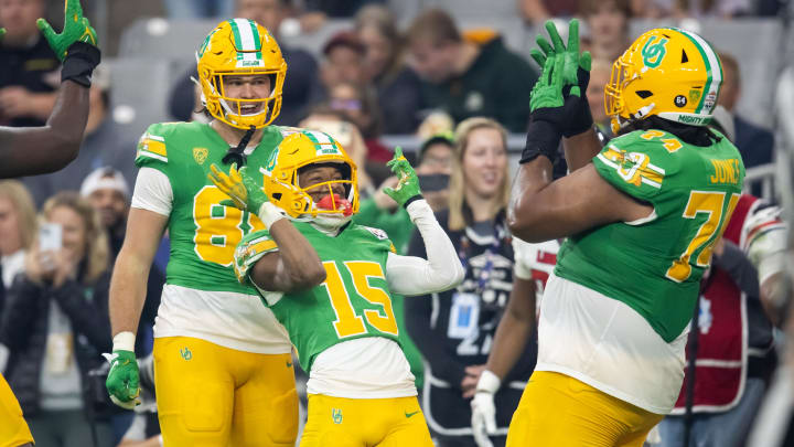 Jan 1, 2024; Glendale, AZ, USA; Oregon Ducks wide receiver Tez Johnson (15) celebrates with offensive lineman Steven Jones (74) and tight end Patrick Herbert (88) after scoring a touchdown against the Liberty Flames during the second half in the 2024 Fiesta Bowl at State Farm Stadium. Mandatory Credit: Mark J. Rebilas-USA TODAY Sports