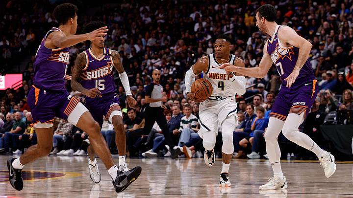 Oct 13, 2024; Denver, Colorado, USA; Denver Nuggets guard Russell Westbrook (4) controls the ball under pressure from Phoenix Suns forward Frank Kaminsky (47) and forward Jalen Bridges (15) and center Oso Ighodaro (4) in the third quarter at Ball Arena. Mandatory Credit: Isaiah J. Downing-Imagn Images