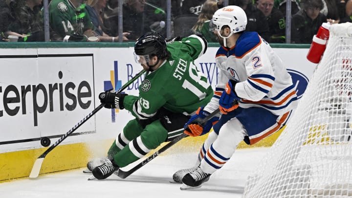 May 25, 2024; Dallas, Texas, USA; Dallas Stars center Sam Steel (18) and Edmonton Oilers defenseman Evan Bouchard (2) chase the puck during the second period in game two of the Western Conference Final of the 2024 Stanley Cup Playoffs at American Airlines Center. Mandatory Credit: Jerome Miron-USA TODAY Sports