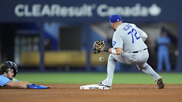 Oct 31, 2025; Toronto, Ontario, CAN; Los Angeles Dodgers second baseman Miguel Rojas (72) makes a double play against Toronto Blue Jays third baseman Addison Barger (47) in the ninth inning during game six of the 2025 MLB World Series at Rogers Centre. Mandatory Credit: John E. Sokolowski-Imagn Images