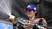 Apr 13, 2024; Austin, TX, USA; Maverick Vinales (12) of Spain and Aprilia Racing sprays the fans with Prosecco after the Americas Grand Prix sprint race at Circuit of The Americas. Mandatory Credit: Jerome Miron-Imagn Images