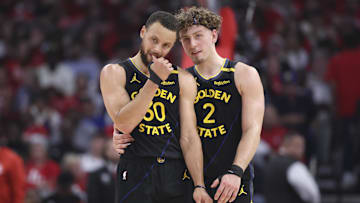 May 4, 2025; Houston, Texas, USA; Golden State Warriors guard Stephen Curry (30) and guard Brandin Podziemski (2) talk during a timeout during game seven of first round for the 2025 NBA Playoffs against the Houston Rockets at Toyota Center. Mandatory Credit: Troy Taormina-Imagn Images