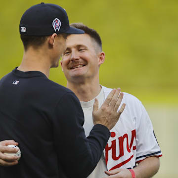 Minnesota Twins relief pitcher Griffin Jax (22) greets his brother Captain Carson Jax after the captain threw out a ceremonial pitch before the game with the Los Angeles Angels at Target Field in Minneapolis on Sept. 11, 2024. Other members of the Jax family participated in the flyover commemorating the 9/11 Remembrance. 