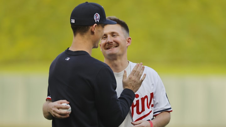 Minnesota Twins relief pitcher Griffin Jax (22) greets his brother Captain Carson Jax after the captain threw out a ceremonial pitch before the game with the Los Angeles Angels at Target Field in Minneapolis on Sept. 11, 2024. Other members of the Jax family participated in the flyover commemorating the 9/11 Remembrance. 