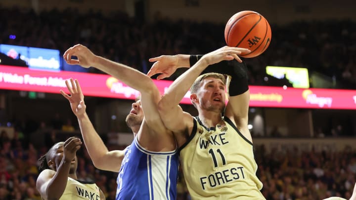 Feb 24, 2024; Winston-Salem, North Carolina, USA;  Wake Forest Demon Deacons forward Andrew Carr (11) battles for the ball against Duke Blue Devils center Ryan Young (15) during the second half at Lawrence Joel Veterans Memorial Coliseum. Mandatory Credit: Cory Knowlton-USA TODAY Sports