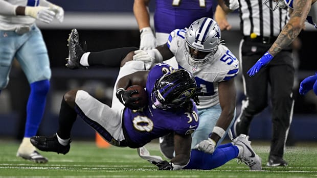 Dallas Cowboys linebacker Shemar James tackles Baltimore Ravens running back D'Ernest Johnson
