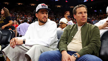 Jun 30, 2024; Phoenix, Arizona, USA; Phoenix Suns guard Devon Booker sits with Phoenix Mercury owner Mat Ishbia during the game between the Indiana Fever and the Phoenix Mercury at Footprint Center. Mandatory Credit: Mark J. Rebilas-Imagn Images