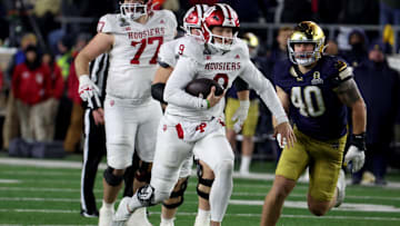 Dec 20, 2024; Notre Dame, Indiana, USA; Indiana Hoosiers quarterback Kurtis Rourke (9) scrambles against Notre Dame Fighting Irish defensive lineman Joshua Burnham (40) during the second half at Notre Dame Stadium. Mandatory Credit: Trevor Ruszkowski-Imagn Images