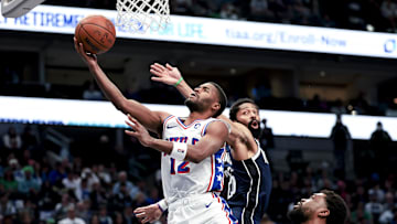 Mar 16, 2025; Dallas, Texas, USA;  Philadelphia 76ers guard Jared Butler (12) shoots past Dallas Mavericks guard Spencer Dinwiddie (26) during the second half at American Airlines Center. Mandatory Credit: Kevin Jairaj-Imagn Images