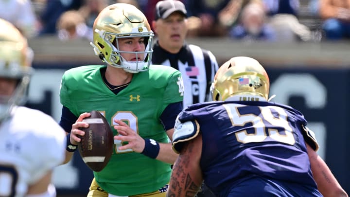 Apr 20, 2024; Notre Dame, IN, USA; Notre Dame Fighting Irish quarterback CJ Carr (12) is pressured by defensive lineman Sean Sevillano Jr. (59) in the second half of the Blue-Gold Game at Notre Dame Stadium. Mandatory Credit: Matt Cashore-USA TODAY Sports