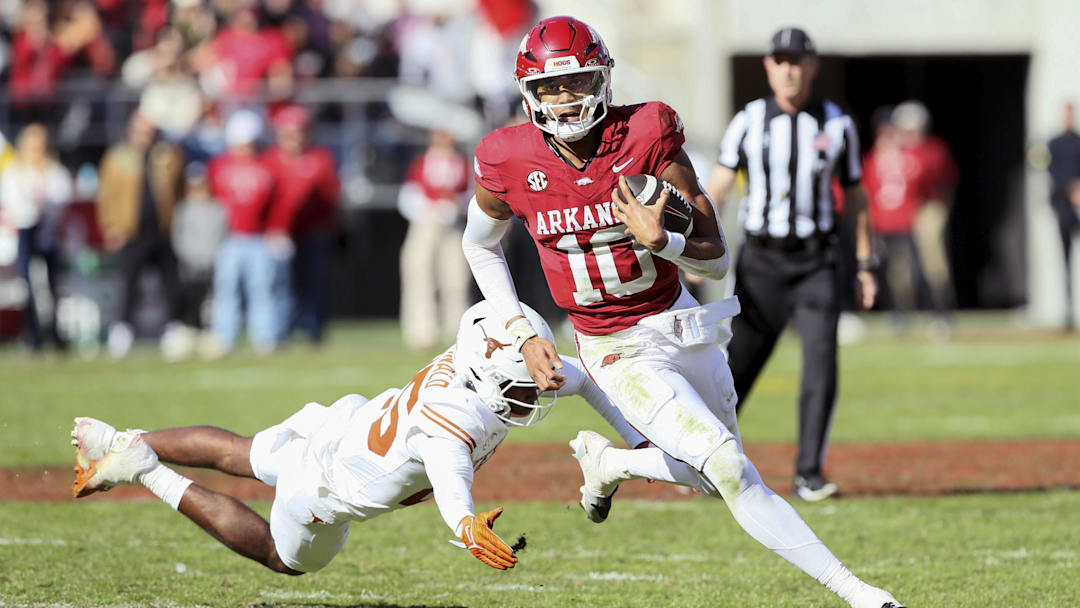 Nov 16, 2024; Fayetteville, Arkansas, USA; Arkansas Razorbacks quarterback Taylen Green (10) rushes in the third quarter as Texas Longhorns defensive back Jelani McDonald (25) defends at Donald W. Reynolds Razorback Stadium. Texas won 20-10. Mandatory Credit: Nelson Chenault-Imagn Images