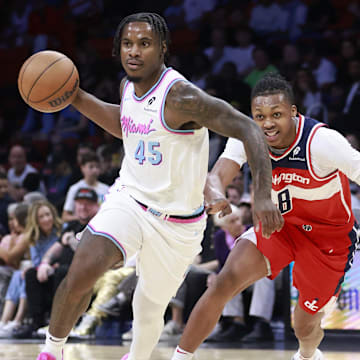 Apr 13, 2025; Miami, Florida, USA;  Miami Heat guard Davion Mitchell (45) passes in front of Washington Wizards guard Bub Carrington (8) during the first half at Kaseya Center. Mandatory Credit: Rhona Wise-Imagn Images
