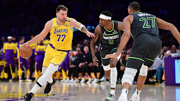 Apr 30, 2025; Los Angeles, California, USA; Los Angeles Lakers guard Luka Doncic (77) moves the ball against Minnesota Timberwolves forward Jaden McDaniels (3) and center Rudy Gobert (27) during the first half in game five of first round for the 2025 NBA Playoffs at Crypto.com Arena. Mandatory Credit: Gary A. Vasquez-Imagn Images