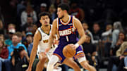 Nov 29, 2025; Phoenix, Arizona, USA; Phoenix Suns guard Devin Booker (1) against Denver Nuggets forward Spencer Jones (21) in the second half at the Mortgage Matchup Center. Mandatory Credit: Mark J. Rebilas-Imagn Images