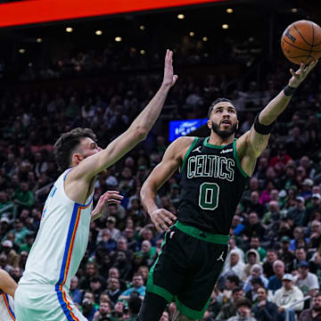 Mar 12, 2025; Boston, Massachusetts, USA; Boston Celtics forward Jayson Tatum (0) makes the basket against Oklahoma City Thunder forward Chet Holmgren (7) in the second quarter at TD Garden. Mandatory Credit: David Butler II-Imagn Images
