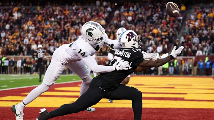 Nov 1, 2025; Minneapolis, Minnesota, USA; Michigan State Spartans defensive back Malcolm Bell (14) commits a pass interference penalty against Minnesota Golden Gophers wide receiver Lemeke Brockington (0) during overtime at Huntington Bank Stadium. Mandatory Credit: Matt Krohn-Imagn Images
