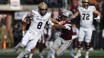 Montana State Bobcats quarterback Justin Lamson (8) carries the ball against Montana Grizzlies safety Micah Harper (2)
