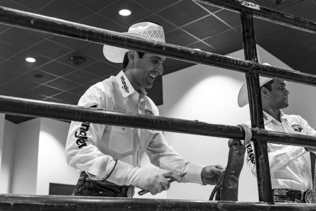 Silvano Alves laughing while working on his bull rope.