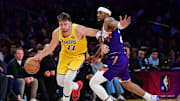 Dec 1, 2025; Los Angeles, California, USA; Los Angeles Lakers guard Luka Doncic (77) moves the ball against Phoenix Suns guard Jordan Goodwin (23) during the second half at Crypto.com Arena. Mandatory Credit: Gary A. Vasquez-Imagn Images