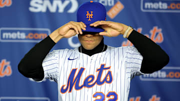 Dec 12, 2024; Flushing, NY, USA; New York Mets right fielder Juan Soto puts on a Mets cap during his introductory press conference at Citi Field. Mandatory Credit: Brad Penner-Imagn Images