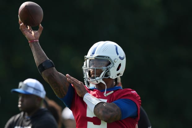 Football player Anthony Richardson throws the ball in practice in a red jersey.