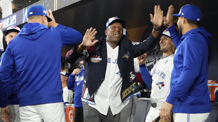 Joe Carter wears the "Home Run Jacket" as he high-fives Toronto Blue Jays players after Carter threw out the first pitch prior to Game 2 of the 2025 World Series in October.