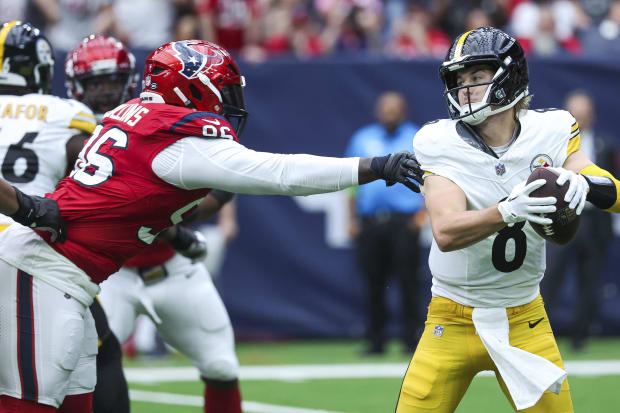 Pittsburgh Steelers quarterback Kenny Pickett (8) attempts to escape Houston Texans defensive tackle Maliek Collins