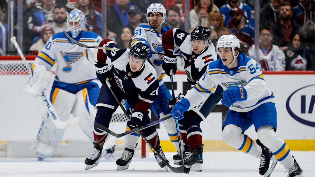 Dec 31, 2025; Denver, Colorado, USA; Colorado Avalanche center Ross Colton (20) and center Jack Drury (18) battle for position with St. Louis Blues defenseman Matthew Kessel (51) as right wing Dalibor Dvorsky (54) defends in the first period at Ball Arena. Mandatory Credit: Isaiah J. Downing-Imagn Images