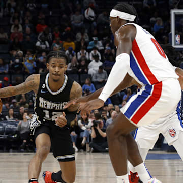 Dec 9, 2022; Memphis, Tennessee, USA; Memphis Grizzlies guard Ja Morant (12) dribbles as Detroit Pistons center Jalen Duren (0) defends during the second half at FedExForum. Mandatory Credit: Petre Thomas-Imagn Images
