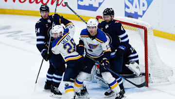 Apr 30, 2025; Winnipeg, Manitoba, CAN; St. Louis Blues forward Nathan Walker (26) and St. Louis Blues forward Alexey Toropchenko (13) jostle for position with Winnipeg Jets defenseman Dylan Samberg (54) and Winnipeg Jets defenseman Neal Pionk (4) during the third period in game five of the first round of the 2025 Stanley Cup Playoffs at Canada Life Centre. Mandatory Credit: Terrence Lee-Imagn Images