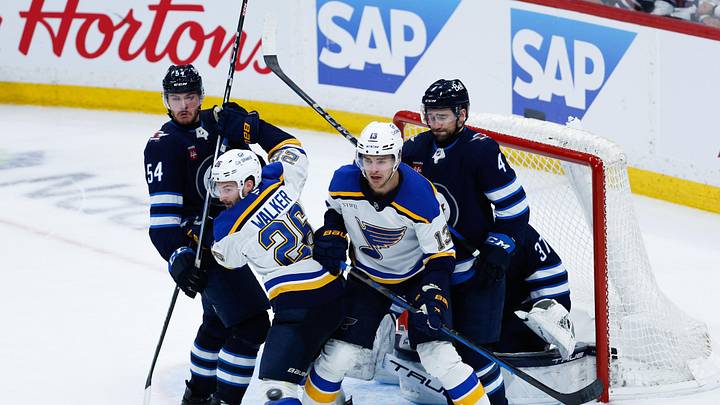 Apr 30, 2025; Winnipeg, Manitoba, CAN; St. Louis Blues forward Nathan Walker (26) and St. Louis Blues forward Alexey Toropchenko (13) jostle for position with Winnipeg Jets defenseman Dylan Samberg (54) and Winnipeg Jets defenseman Neal Pionk (4) during the third period in game five of the first round of the 2025 Stanley Cup Playoffs at Canada Life Centre. Mandatory Credit: Terrence Lee-Imagn Images