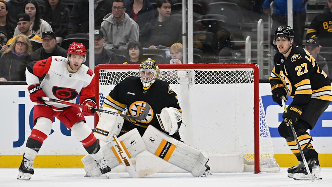 Nov 1, 2025; Boston, Massachusetts, USA; Carolina Hurricanes left wing Taylor Hall (71), Boston Bruins goaltender Jeremy Swayman (1) and defenseman Hampus Lindholm (27) watch the loose puck during the third period at TD Garden. Mandatory Credit: Eric Canha-Imagn Images