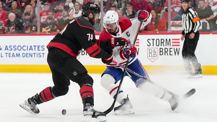 May 21, 2026; Raleigh, North Carolina, USA; Carolina Hurricanes defenseman Jaccob Slavin (74) challenges Montreal Canadiens center Nick Suzuki (14) for the puck during the second period in game one of the Eastern Conferene Final of the 2026 Stanley Cup Playoffs at Lenovo Center. Mandatory Credit: James Guillory-Imagn Images