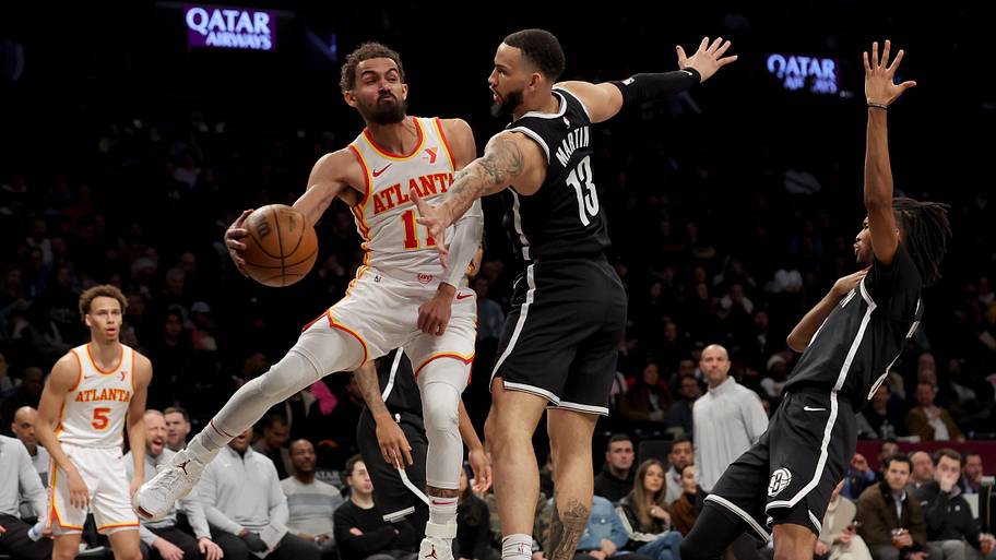 Atlanta Hawks guard Trae Young looks to pass the ball against Brooklyn Nets guard Tyrese Martin.