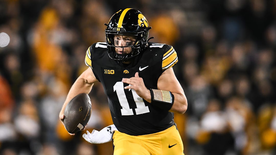 Nov 22, 2025; Iowa City, Iowa, USA; Iowa Hawkeyes quarterback Mark Gronowski (11) scrambles for yards against the Michigan State Spartans during the fourth quarter at Kinnick Stadium. Mandatory Credit: Jeffrey Becker-Imagn Images