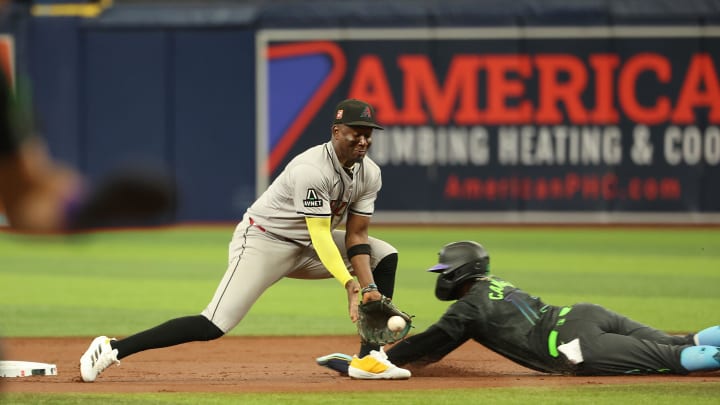 Aug 17, 2024; St. Petersburg, Florida, USA;  Arizona Diamondbacks shortstop Geraldo Perdomo (2) attempts to tag out Tampa Bay Rays third baseman Junior Caminero (13) after he steals second base during the first inning at Tropicana Field. Mandatory Credit: Kim Klement Neitzel-USA TODAY Sports