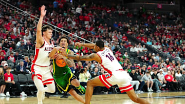 Mar 15, 2024; Las Vegas, NV, USA; Oregon Ducks guard Jadrian Tracey (22) dribbles between Arizona Wildcats guard Pelle Larsson (3) and Arizona Wildcats forward Keshad Johnson (16) during the first half at T-Mobile Arena. Mandatory Credit: Stephen R. Sylvanie-Imagn Images